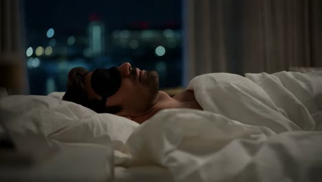 man sleeping in a hotel room at night