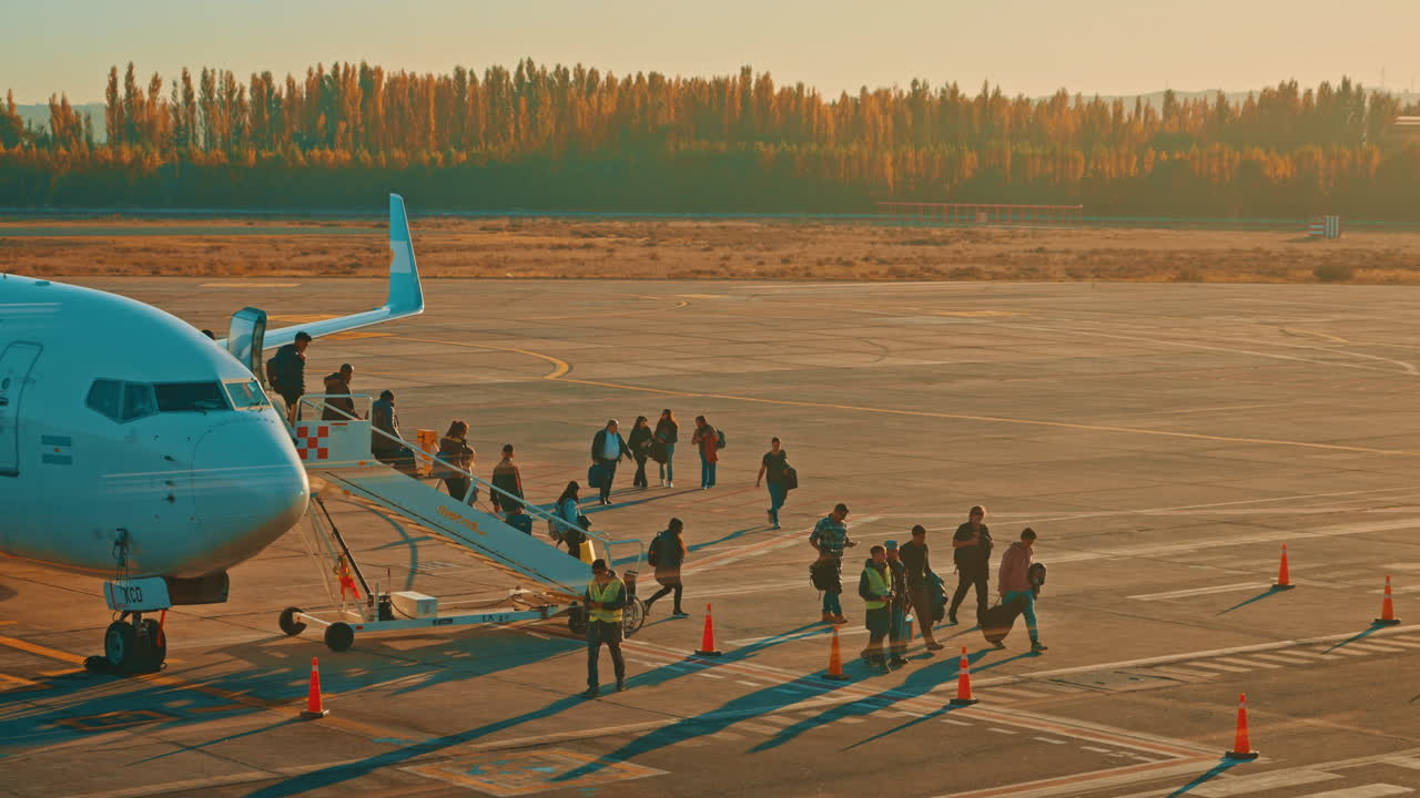 Passengers Disembarking an Airplane on a Sunny Airport Tarmac