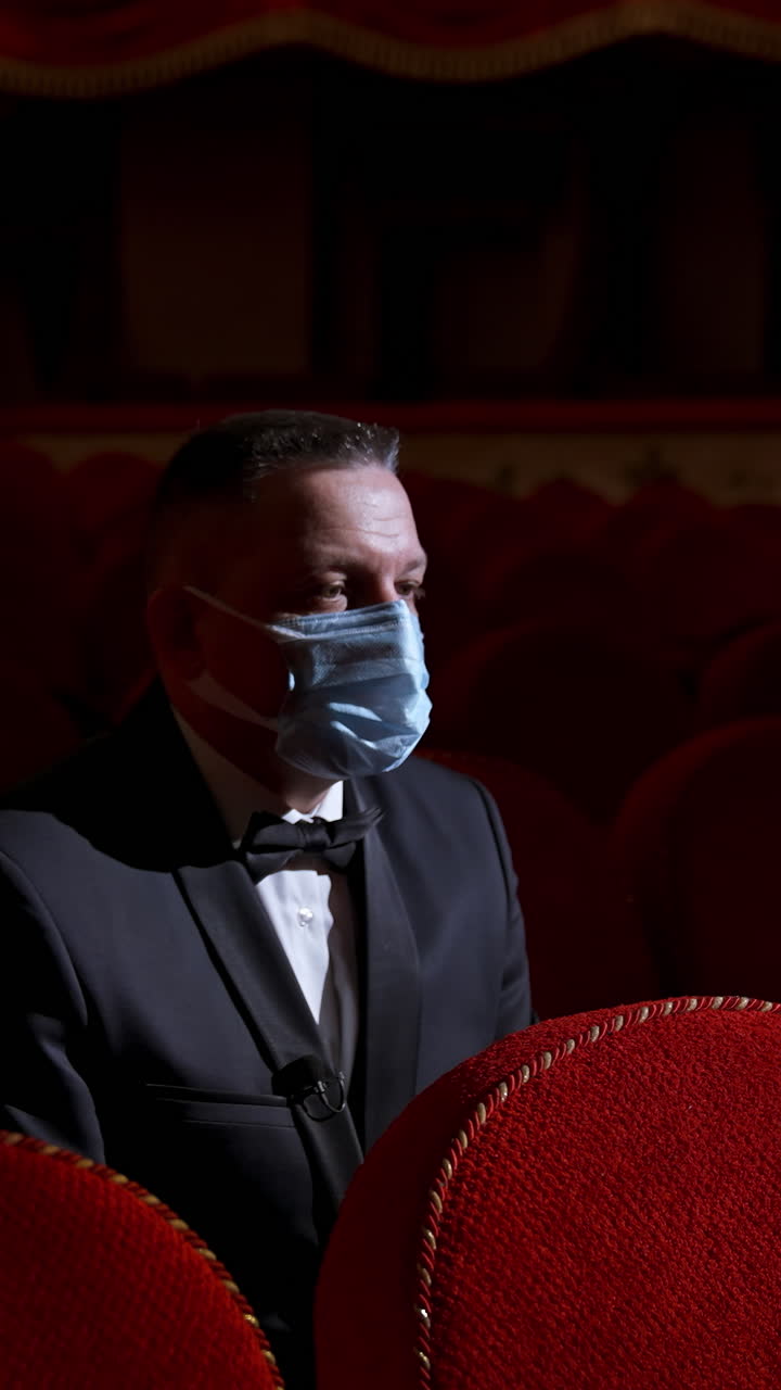 Man in theatre with protection mask. Man wearing face protective medical masks for protection from virus