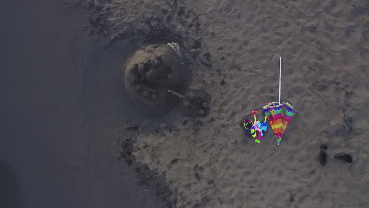 castillo de arena y paraguas de playa
