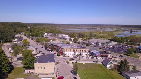 panning aerial of buildings and street traffic in montague, michigan