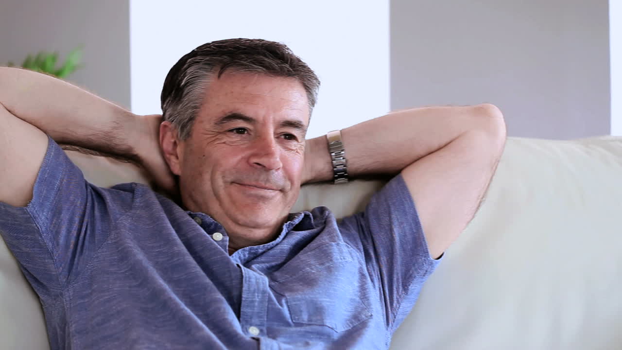 hombre maduro feliz relajándose en su sofá