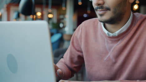 man working on a laptop in a cafe