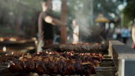 Shish-kebabs-preparing-on-skewers-outdoors.-Chef-male-cooking-meat-outside