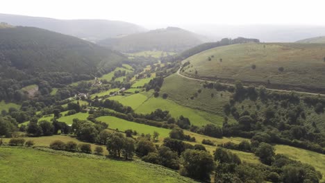 aerial view idyllic vast lush green rural misty mountain valley countryside slow pull back descend