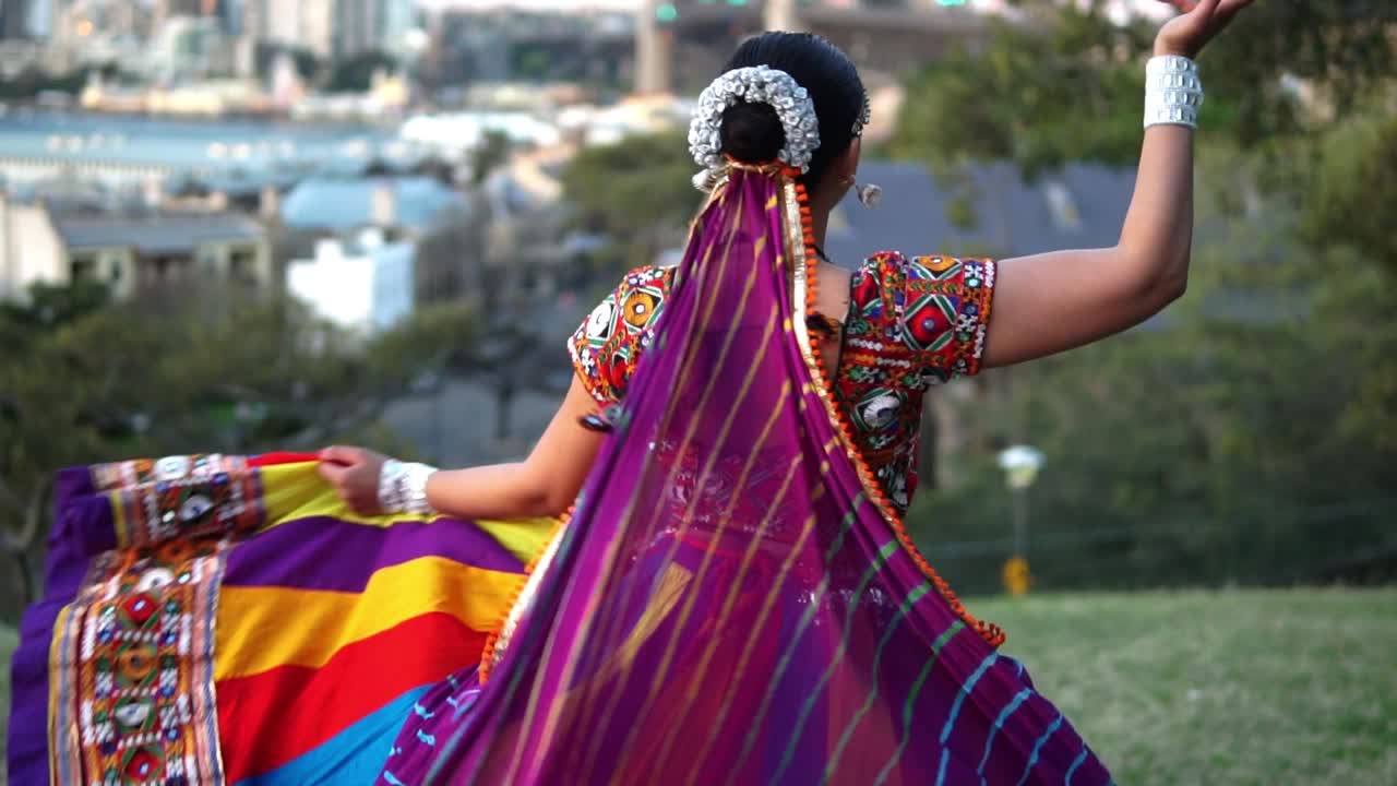 mujer india con trajes coloridos bailando danza tradicional india en el jardín de sídney, australia