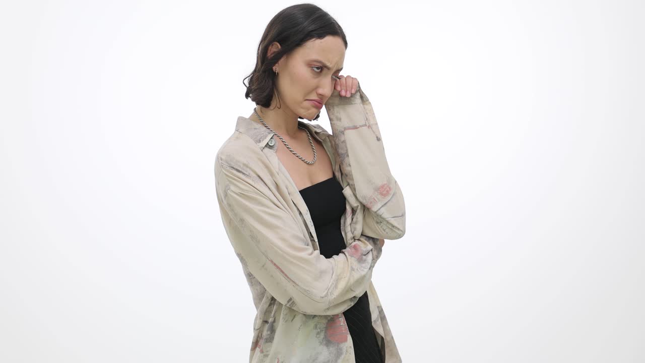 Pensive woman with a thoughtful expression on a white background