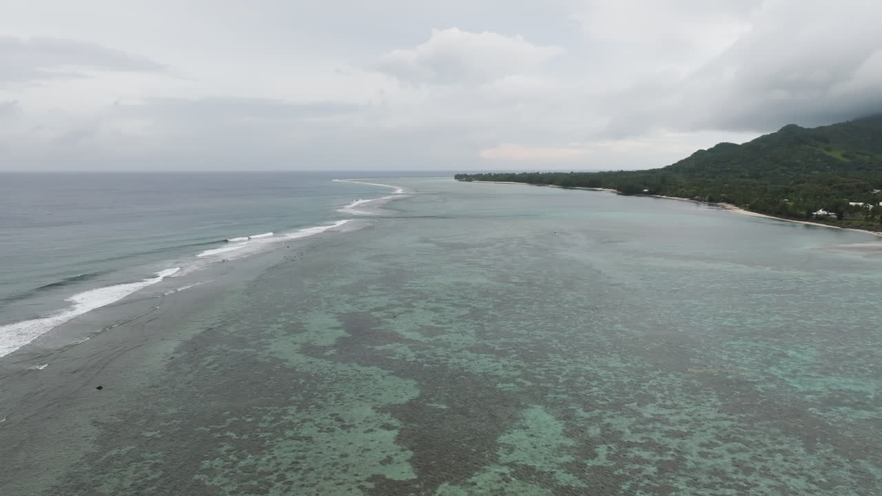 Stunning aerial overview of tropical paradise coastal fringing reef protecting waters in Rarotonga Cook Islands
