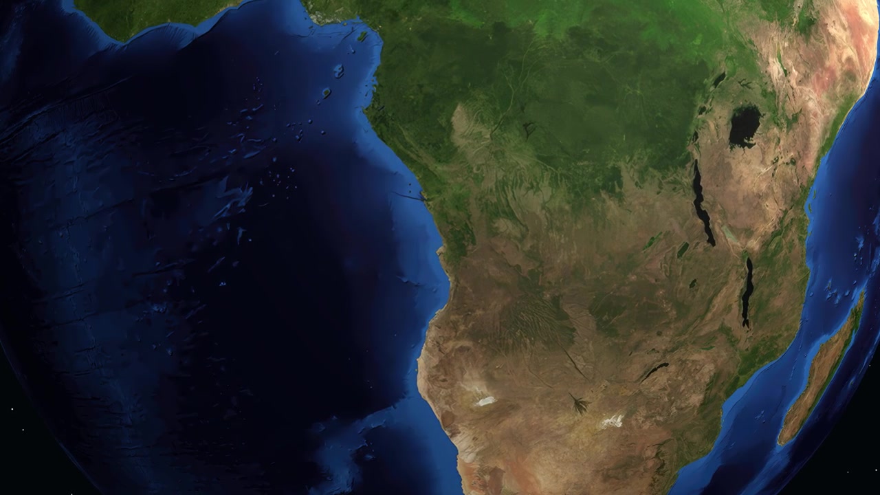 Cyfrowa animacja przybliża się z kosmosu do Luandy w Angoli, wyświetlając konkretne współrzędne geograficzne i lokalizację.