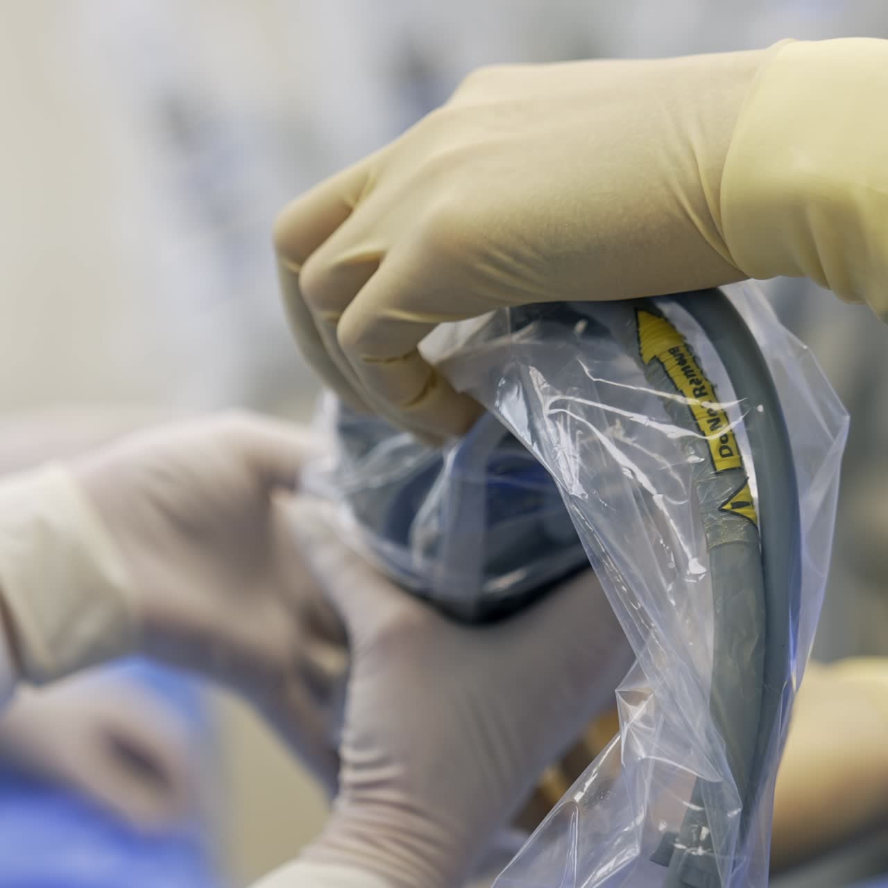 Hands of medics in white latex gloves holding a robotic arm. Doctors are getting ready to use Da Vinci robot equipment at operation