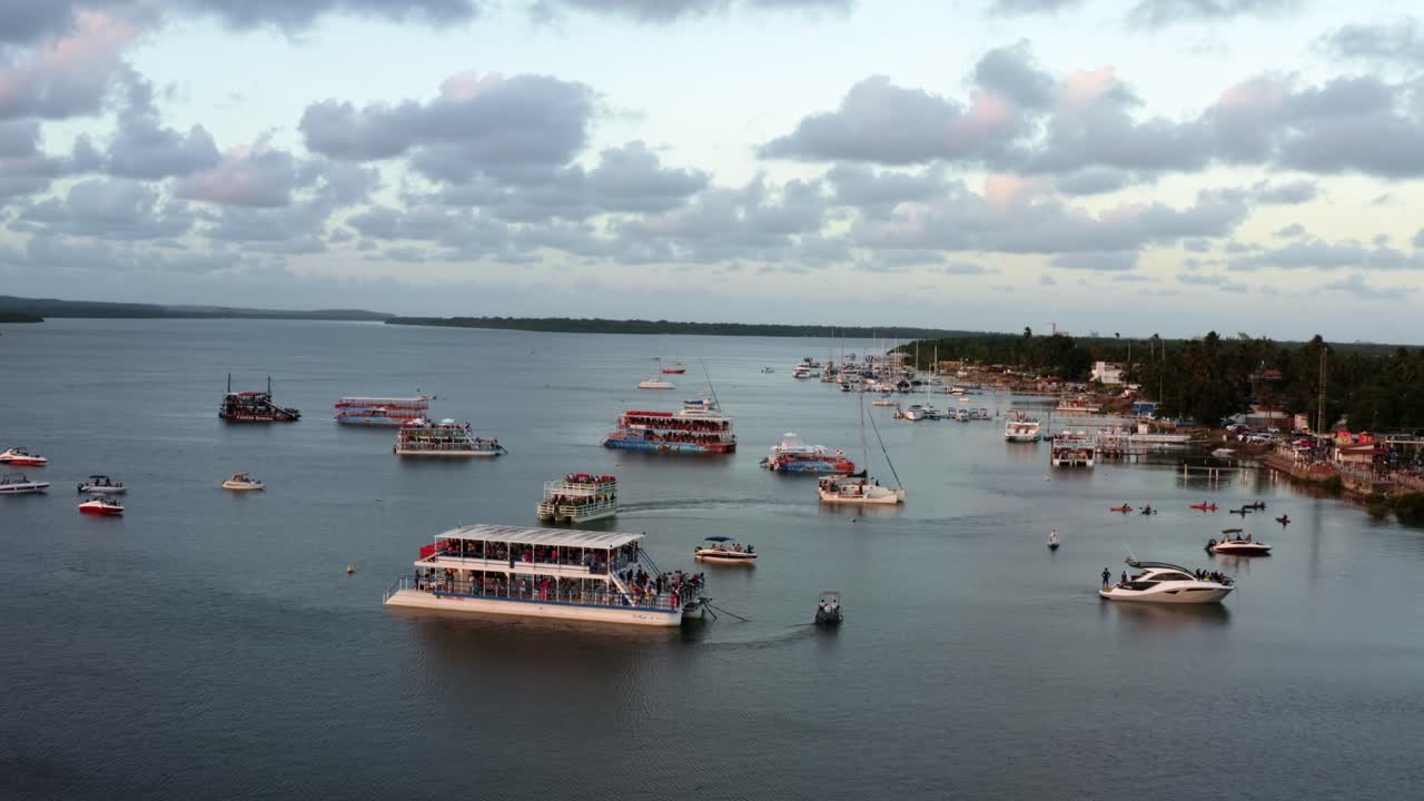 toma aérea de la famosa playa de caimanes, un río en cabedelo, paraiba, brasil, cerca de la capital costera de joao pessoa, con un grupo de botes turísticos viendo la puesta de sol