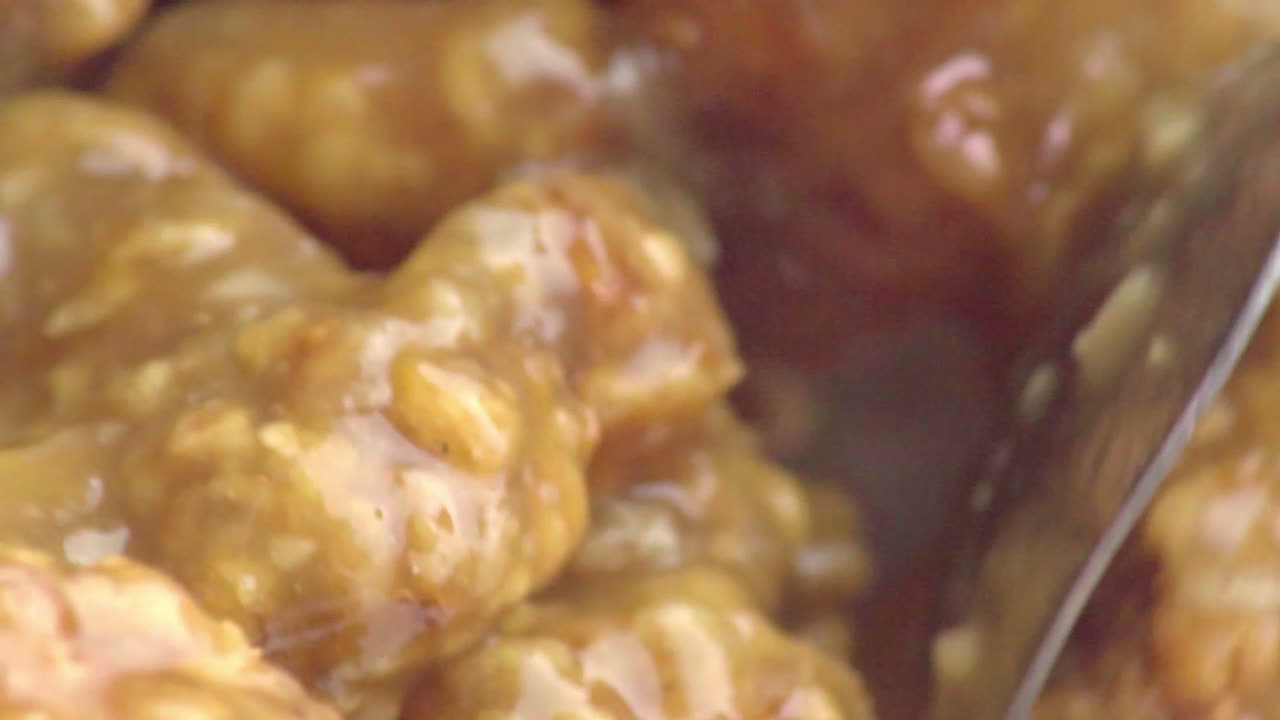 맛있고 맛있는 요리된 치킨 멘타이가 스테인리스 스틸 스푼과 섞이고 섞이고 있습니다.