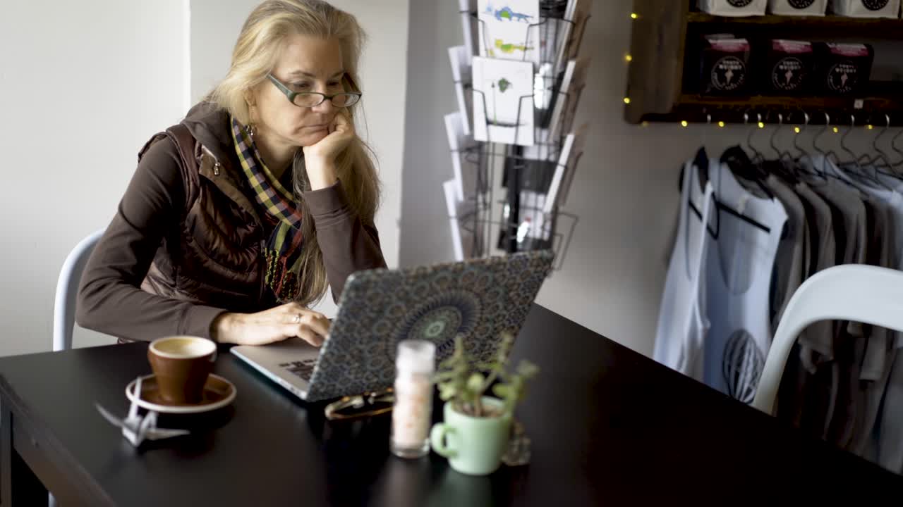Donna che lavora al computer portatile al bar