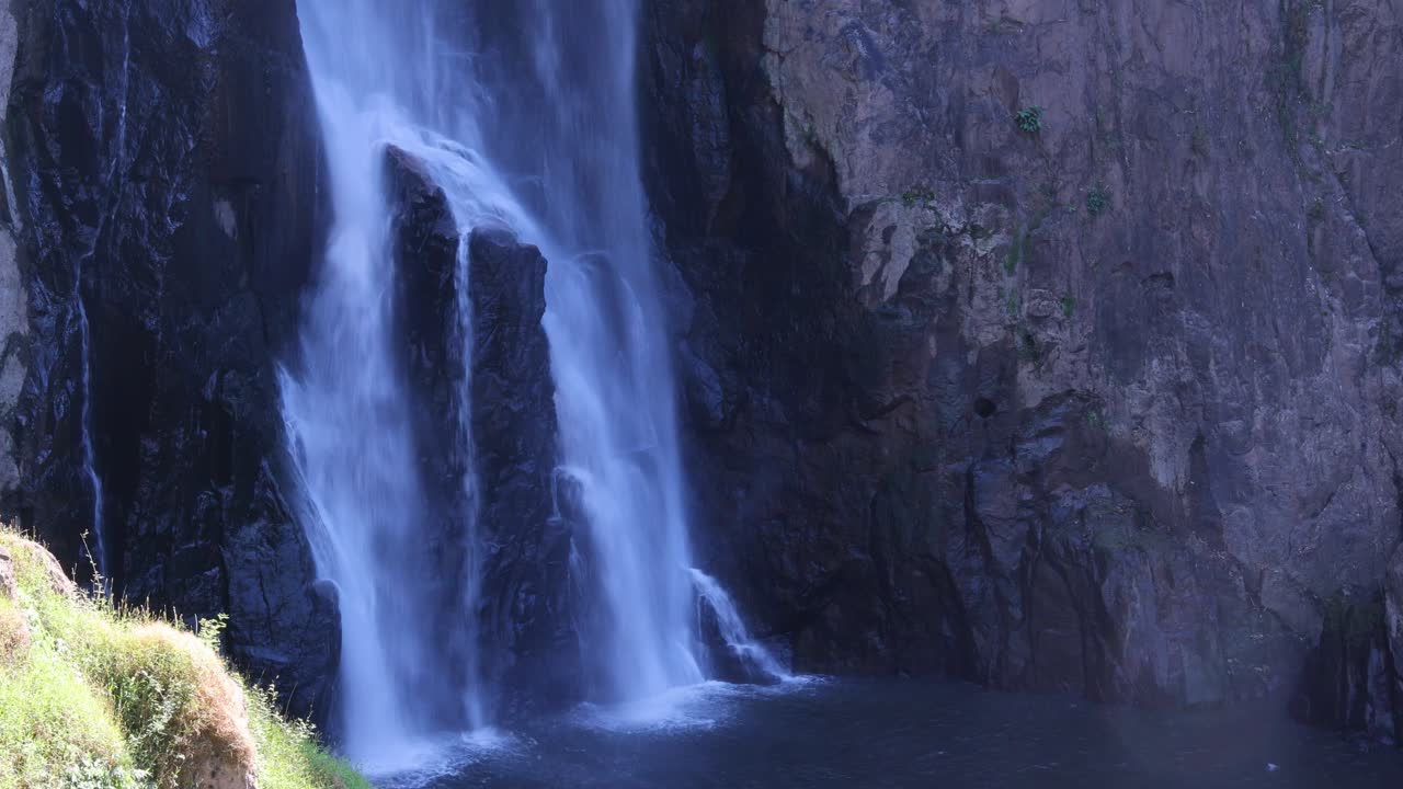 el agua cae en cascada por un acantilado rocoso.