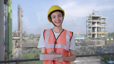 happy indian female construction worker taking notes of building