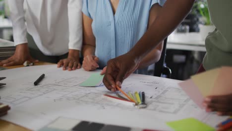 manos de diversas mujeres de negocios que trabajan juntas en la oficina, decidiendo la paleta de colores