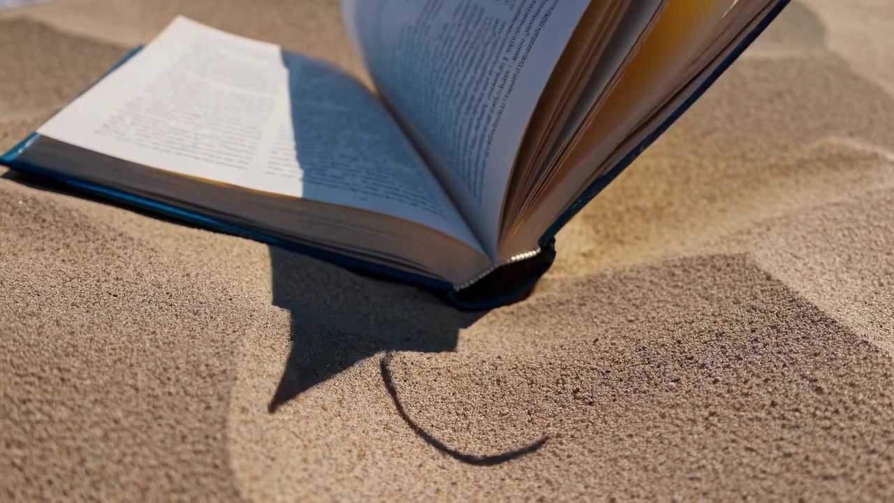 Open Book with Pages Turning on Sandy Beach