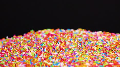 vibrant sprinkles cascade against a dark background