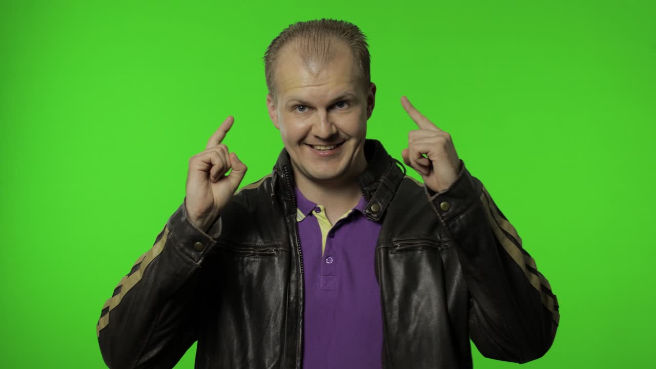 Flot positiv rockermand i brun denimjakke peger finger mod kameraet. Chroma key
