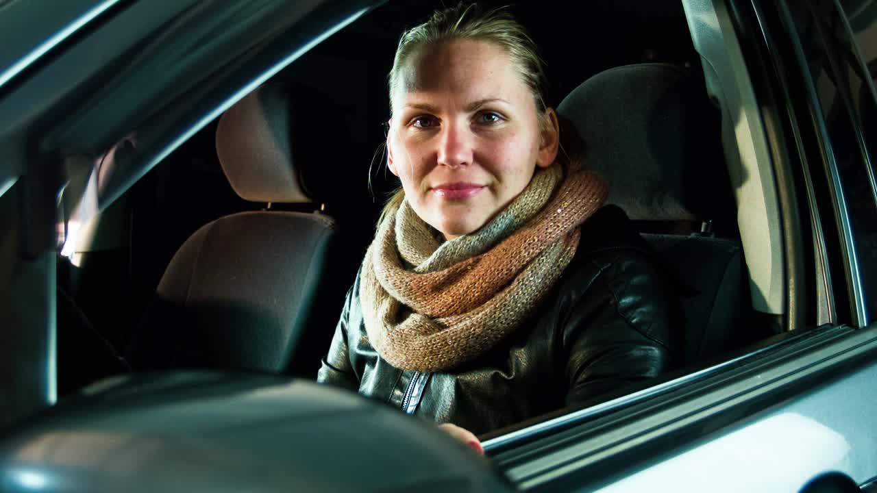 The Girl On a Parking Lowers Glass And Smiles