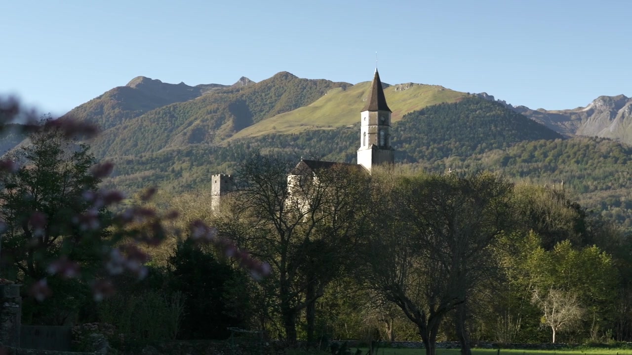 Näkymä Pyreneiden Castet-kylään ja sen kirkkoon, joka sijaitsee kukkulan laella. Alue: Nouvelle-Aquitaine.
