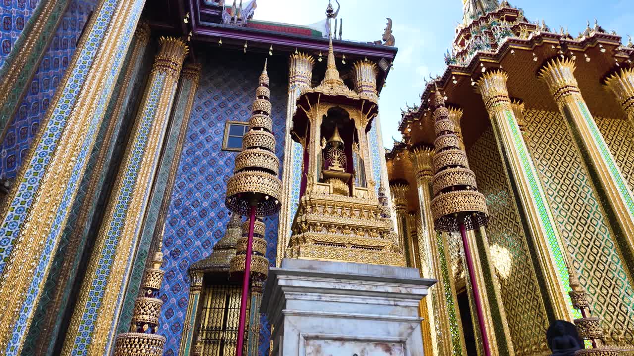 澄み切った青空の下、金色の尖塔を持つ華やかなバンコクの寺院