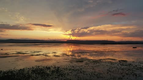 puesta de sol sobre un lago tranquilo con nubes