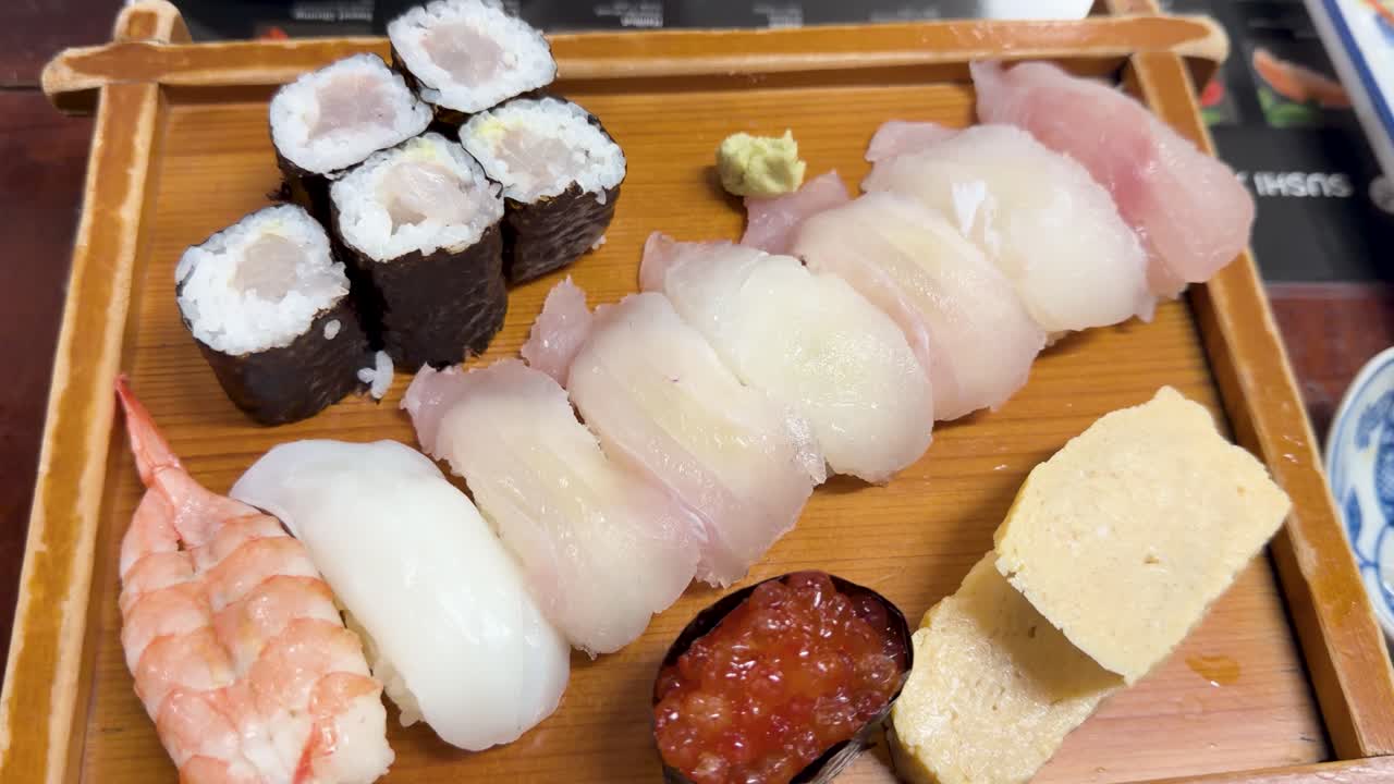わさびと生姜が添えられた新鮮な握り、巻き寿司、刺身のオーバーヘッドショット。