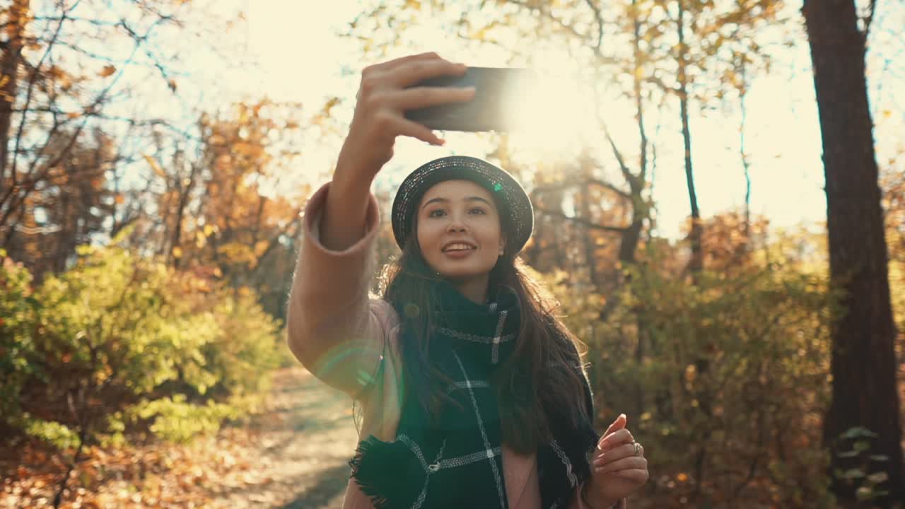mujer tomando una selfie en un parque de otoño