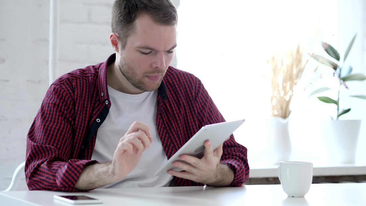 Young Man Browsing and Scrolling on Tablet