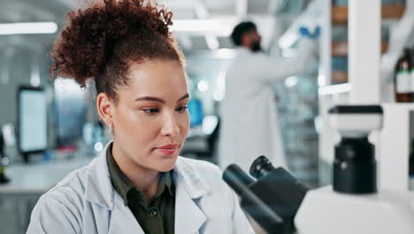 scientist working in a lab with a microscope