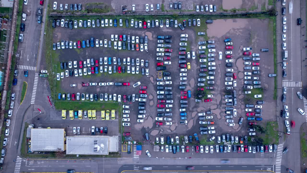 timelapse aéreo de un estacionamiento rústico después de la lluvia, mañana brumosa, dominación de coches blancos