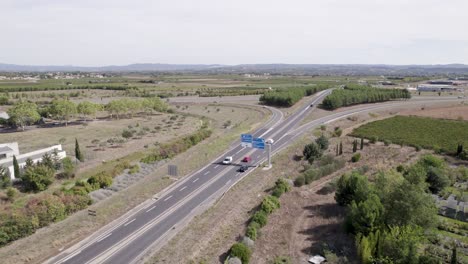 automóviles que ingresan a la ciudad de clermont-l'hérault en el sur de francia, tiro aéreo izquierdo