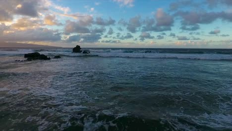 flying-low-over-waves-on-the-coast-of-Maui-Hawaii-at-sunset,-dolly-forward