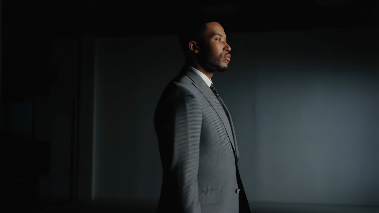 Portrait of a businessman in a gray suit in a dark, professional environment