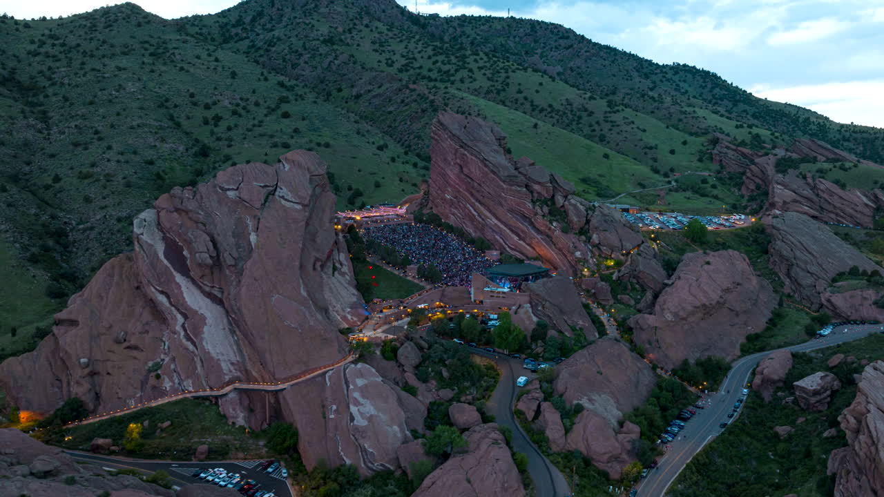 Epic arcing aerial hyperlapse of Red Rocks amphitheater concert near Morrison