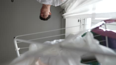 laundry drying in a room with person in the background