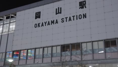 Okayama-JR-station-in-Central-Japan,-Pan-Establishing-Shot-of-Exterior-at-Night