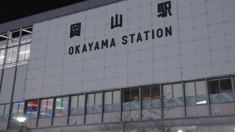 estación okayama jr en el centro de japón, panorámica que establece una toma del exterior por la noche