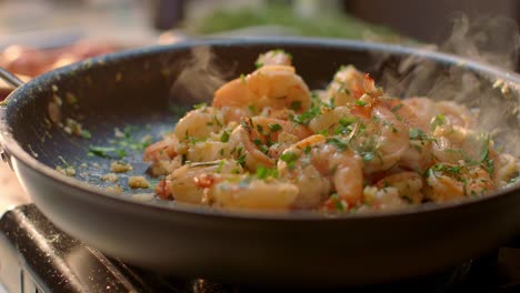 fresh shrimp cooking in a steaming skillet on stove