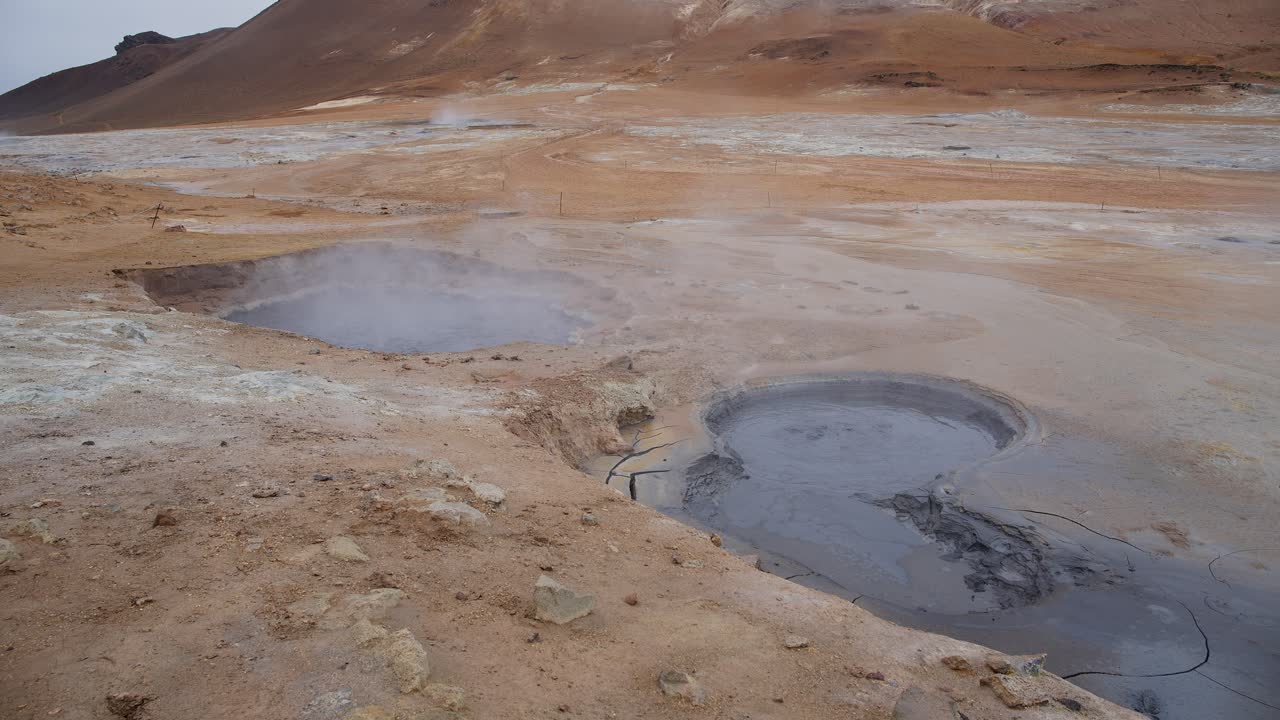 Steaming hot geothermal mud pools in the rugged Icelandic countryside