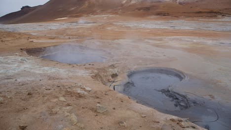 piscinas de barro geotérmico calientes y humeantes en el escarpado campo islandés