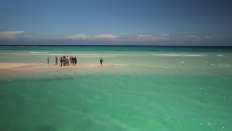 drone shot group friends caribbean beach travel stand on pristine white sandbar, los roques