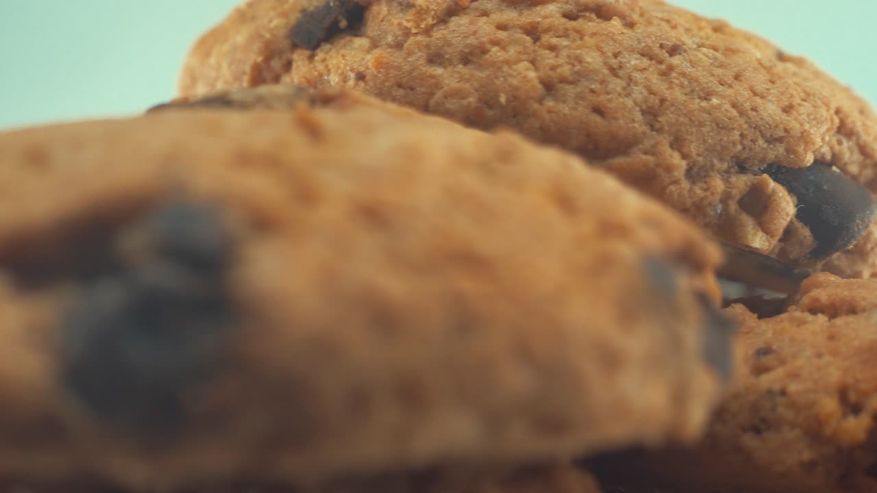 A macro close up shot of a white plate full of delicious chocolate chip cookies, on a 360 rotating stand, studio lighting, slow motion, 4K video