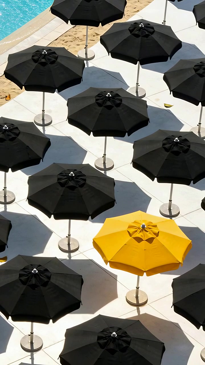 Video verticale: Telecamera panoramica che mostra un ombrello giallo tra quelli neri su un ponte bianco, per contrasto