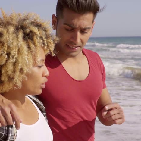 young mixed race couple standing on the beach