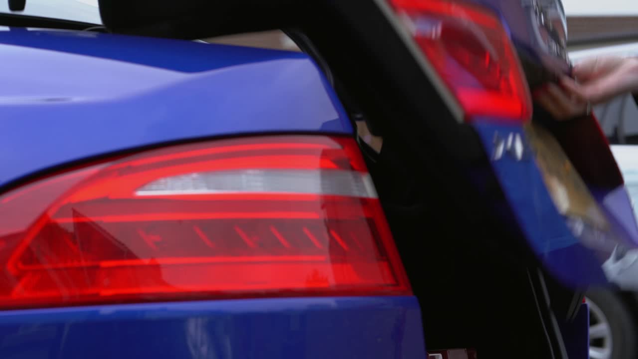 Trunk opens and woman takes flowers from back
