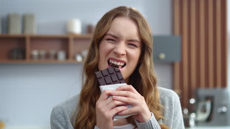 Beautiful-girl-tasting-chocolate-indoors.-Smiling-woman-enjoying-dark-chocolate