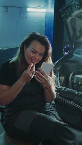 woman applying lipstick in a garage