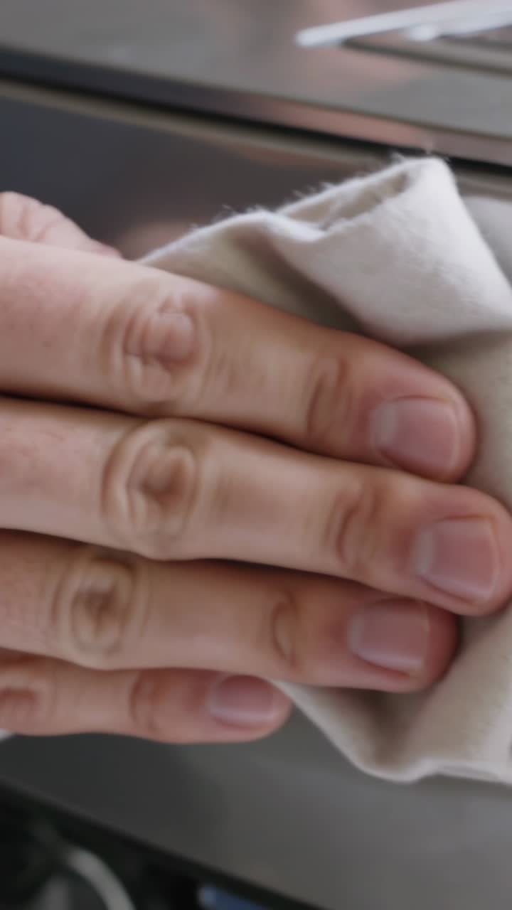 Close-up of Hand Wiping and Cleaning a Kitchen Appliance